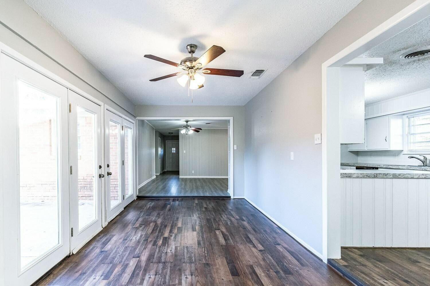4320 48th Street Lubbock, TX 79413 - Photo 14 of 17 a view of a hallway with wooden floor and a kitchen
