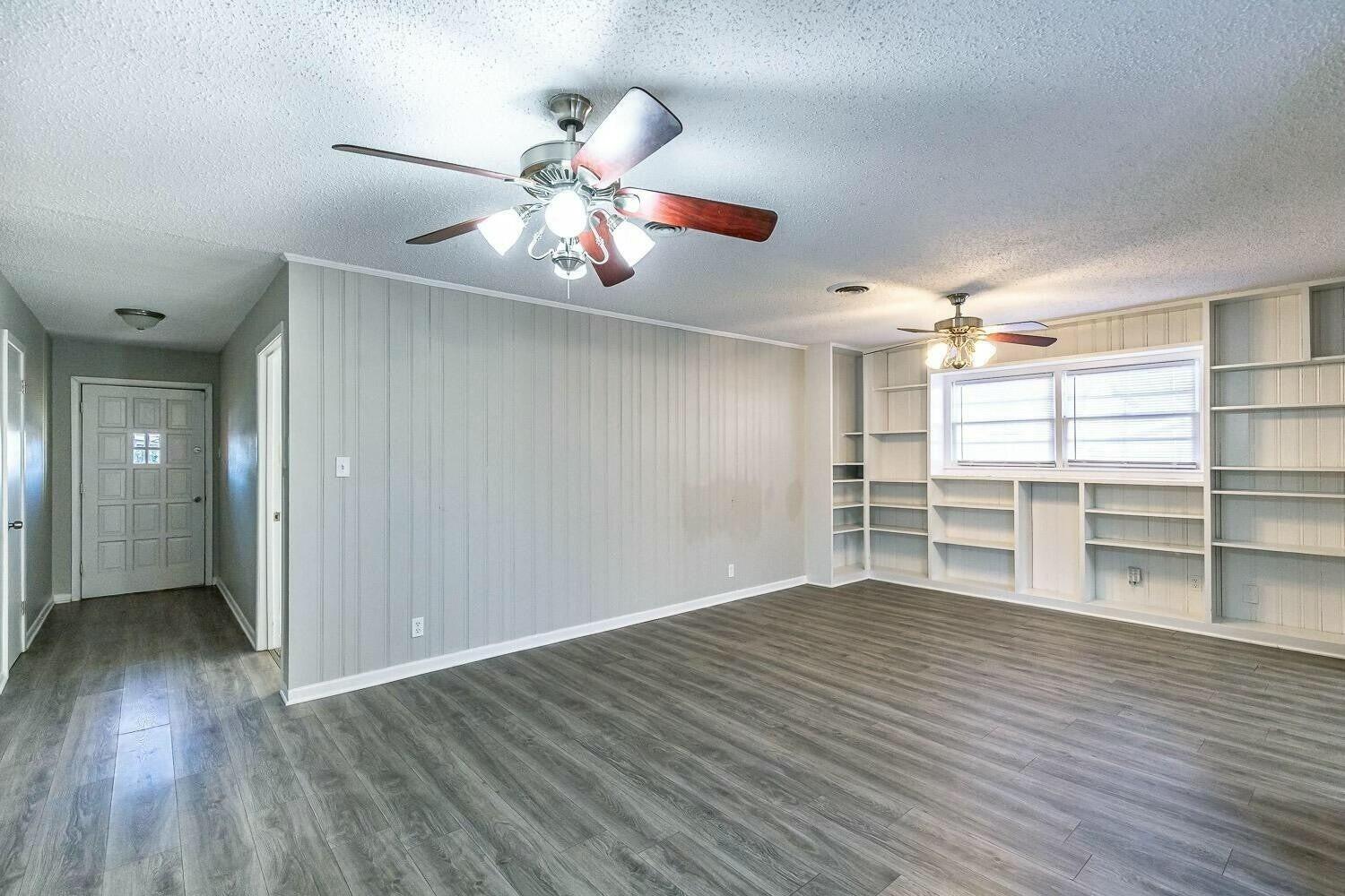 4320 48th Street Lubbock, TX 79413 - Photo 2 of 17 a view of empty room with wooden floor and fan