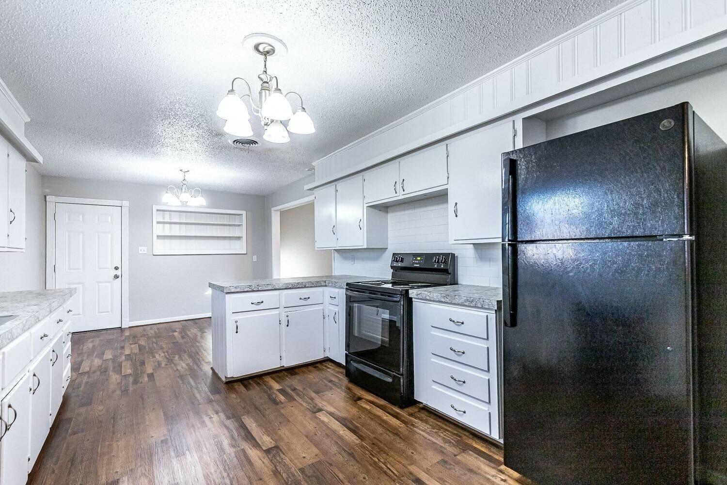 4320 48th Street Lubbock, TX 79413 - Photo 5 of 17 a kitchen with a refrigerator and a stove top oven