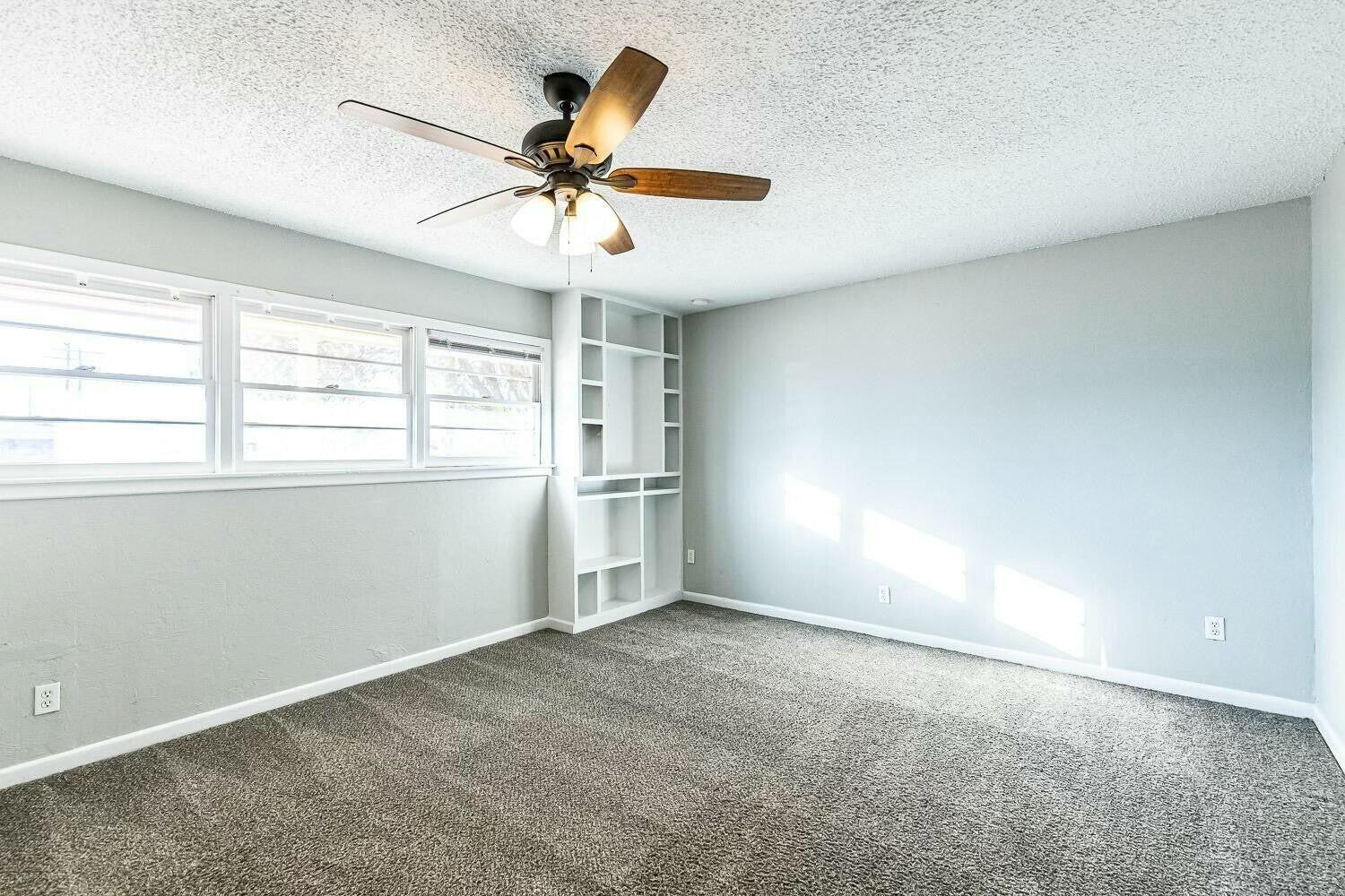 4320 48th Street Lubbock, TX 79413 - Photo 7 of 17 an empty room with windows and fan