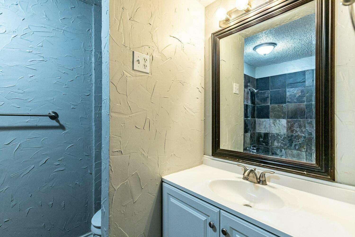 4320 48th Street Lubbock, TX 79413 - Photo 8 of 17 a bathroom with a sink and a mirror