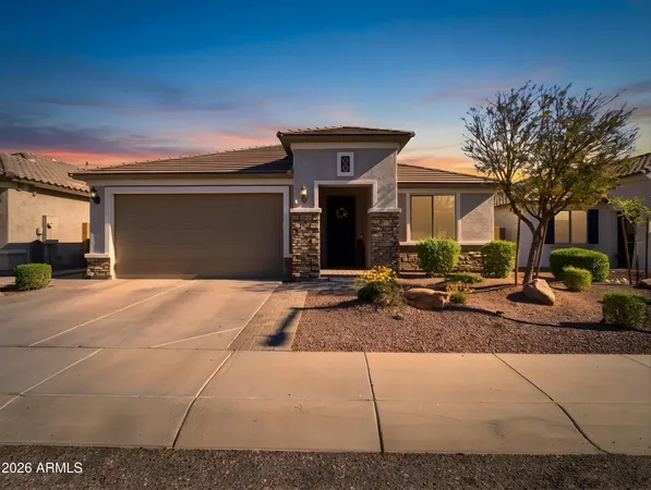 a front view of a house with garage and outdoor seating