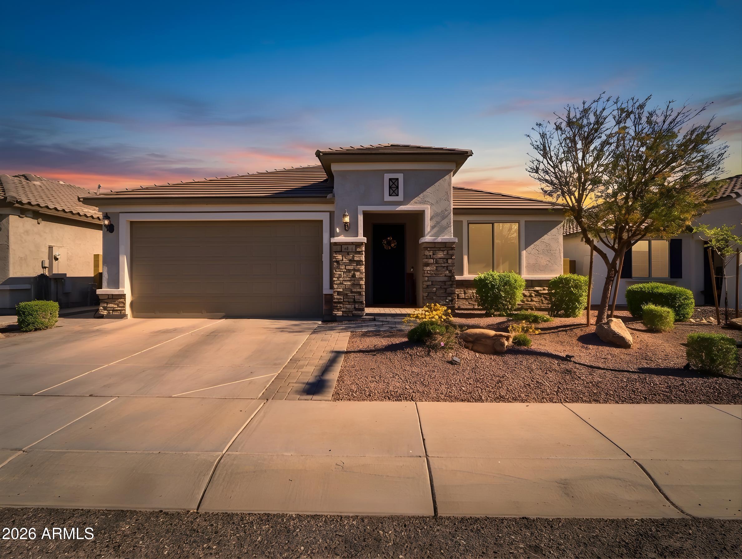 a front view of a house with garage and outdoor seating