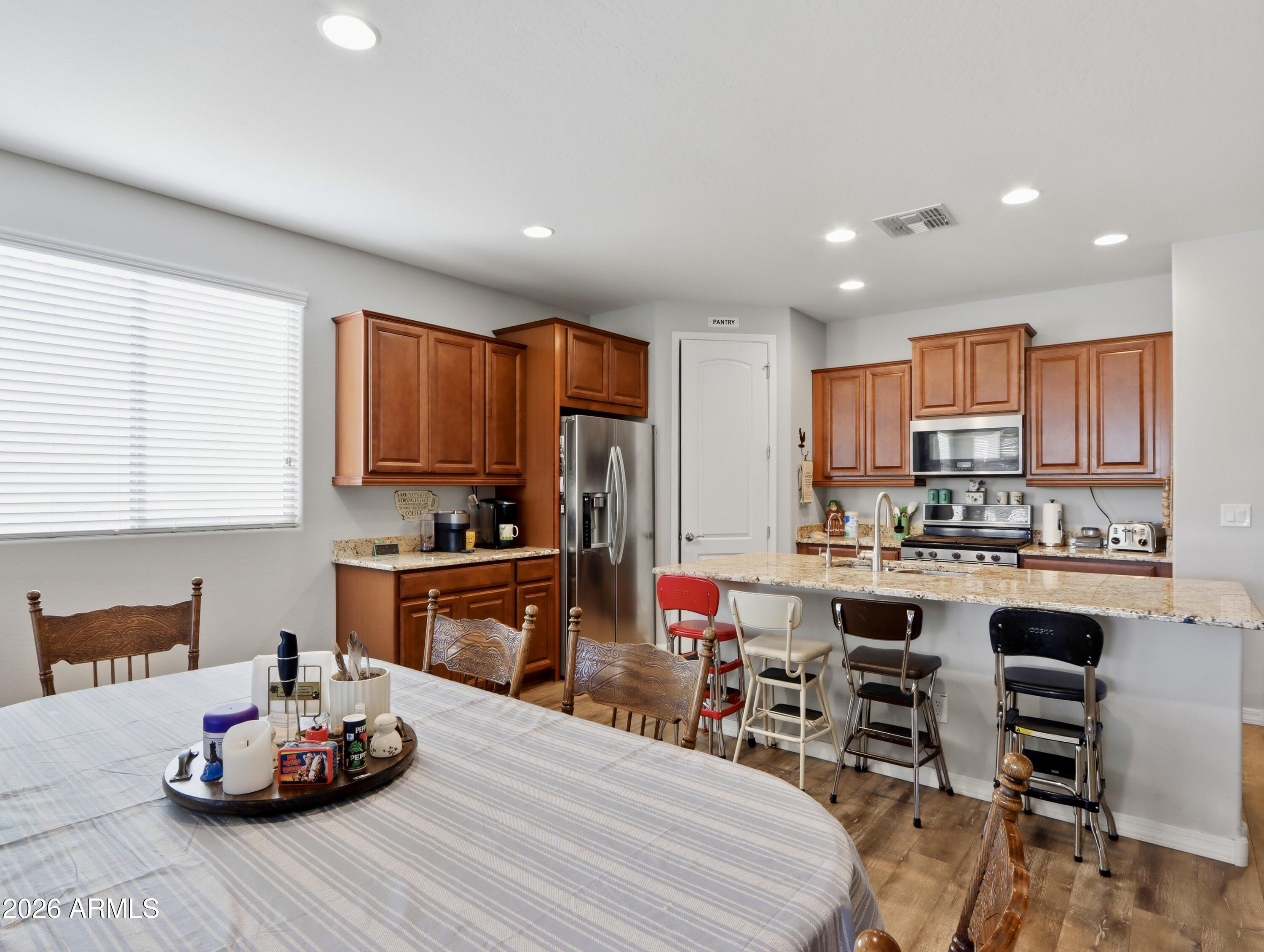 6421 Roy Rogers Road Phoenix, AZ 85083 - Photo 2 of 17 a kitchen with kitchen island granite countertop wooden cabinets and center island with chairs
