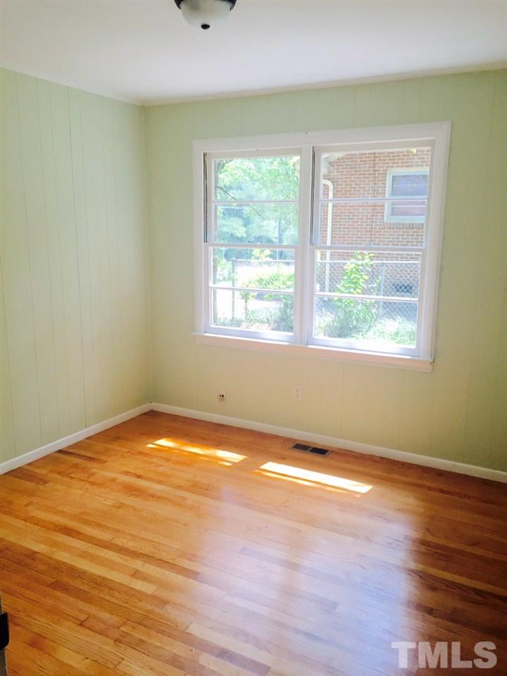 2706 Milburnie Road Raleigh, NC 27610 - Photo 4 of 8 a view of an empty room with wooden floor and a window