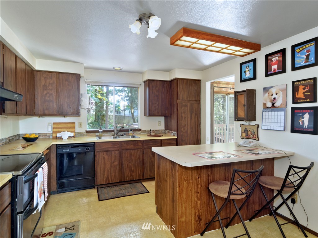 3619 Southeast 19th Court Renton, WA 98058 - Photo 6 of 21 a kitchen with a stove a refrigerator and a dining table