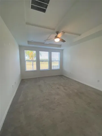 an empty room with windows and ceiling fan view