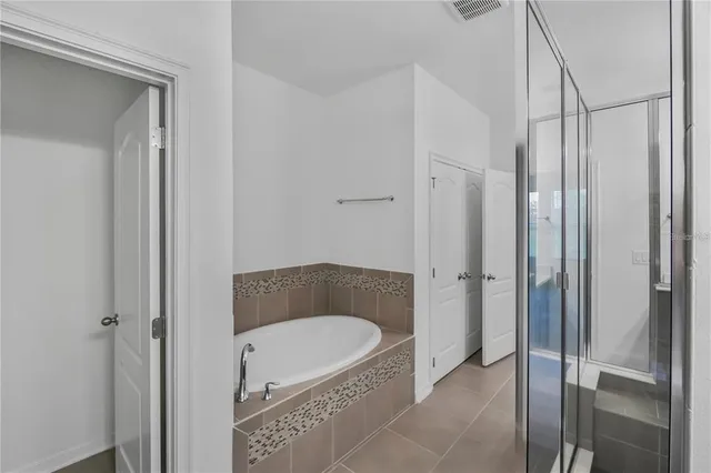 a bathroom with a tub shower a sink and a mirror