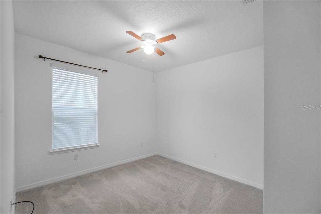 7047 Oxbow Road Minneola, FL 34715 - Photo 19 of 33 an empty room with windows and fan