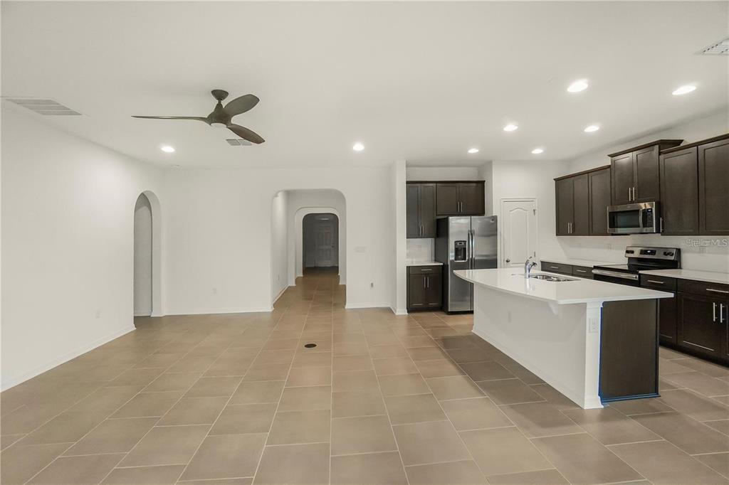 7047 Oxbow Road Minneola, FL 34715 - Photo 5 of 33 a large kitchen with stainless steel appliances kitchen island granite countertop a refrigerator oven a sink a counter top space and cabinets