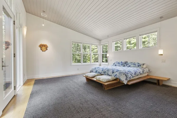a bedroom with a bed painting and a window
