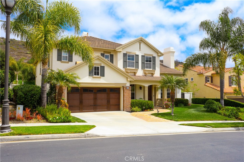 a front view of a house with a garden and trees