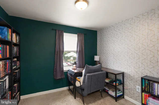 a living room with furniture a bookshelf and a window