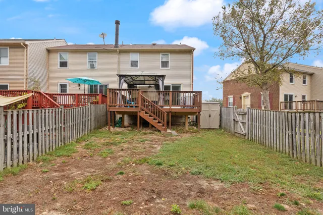a view of a house with wooden deck and furniture