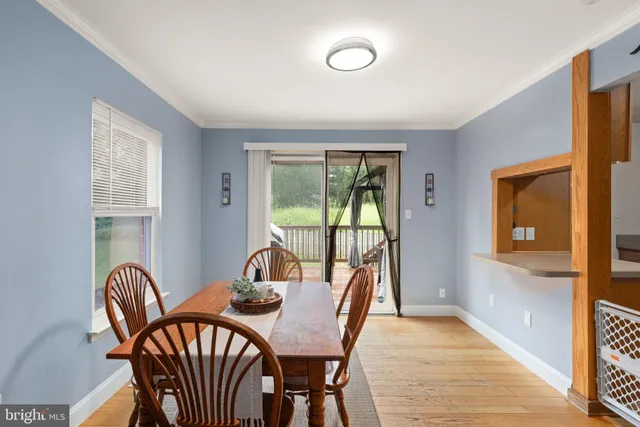 a view of a dining room with furniture a rug and wooden floor