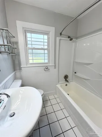 a bathroom with a bathtub a sink and a window