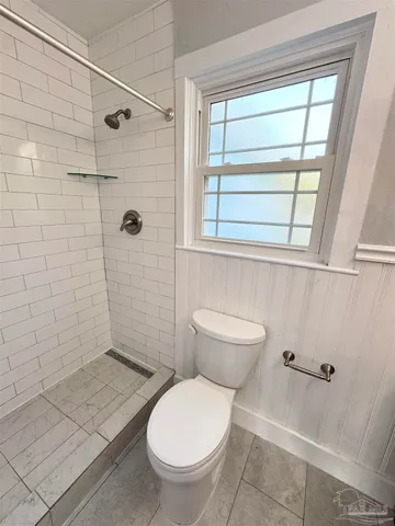 a bathroom with a toilet and a shower