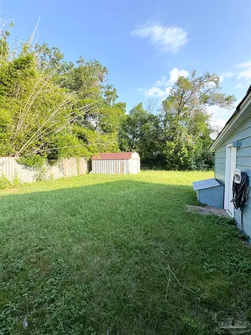 a view of yard with swimming pool and wooden fence