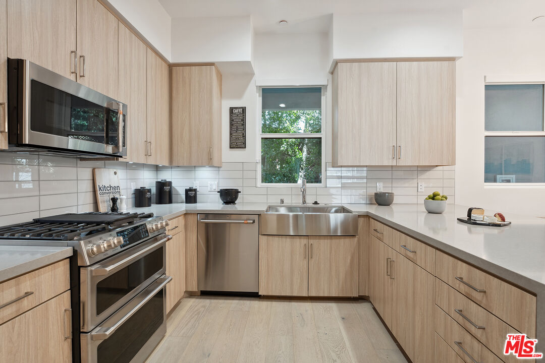1746 Garfield Place, Unit 202 Los Angeles, CA 90028 - Photo 7 of 30 a kitchen with stainless steel appliances a white stove top oven and sink