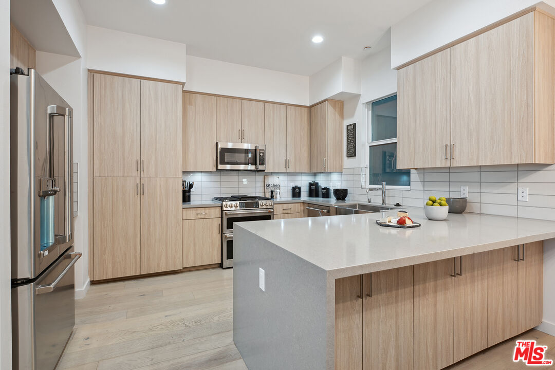 1746 Garfield Place, Unit 202 Los Angeles, CA 90028 - Photo 8 of 30 a kitchen with a refrigerator a stove top oven a sink and cabinets
