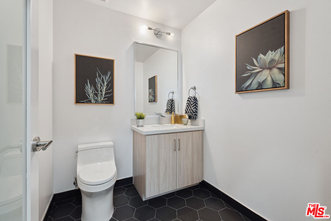 1746 Garfield Place, Unit 202 Los Angeles, CA 90028 - Photo 9 of 30 a bathroom with a toilet a sink and mirror