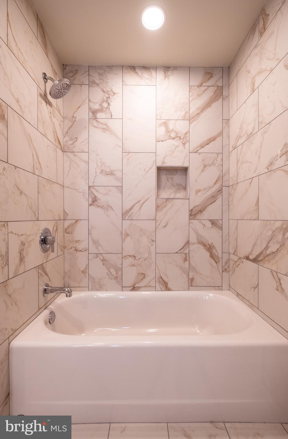 2301-61 John F Kennedy Boulevard, Unit 104 Philadelphia, PA 19103 - Photo 29 of 47 a bathroom with a bathtub and shower