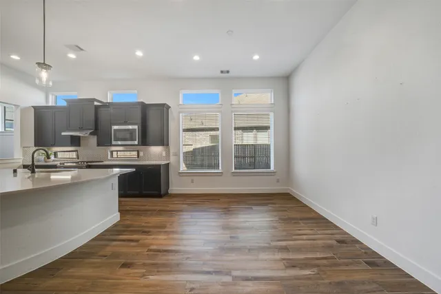 a large kitchen with stainless steel appliances a large counter top and oven