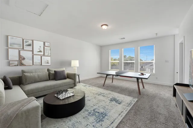 a living room with furniture a rug and a large window
