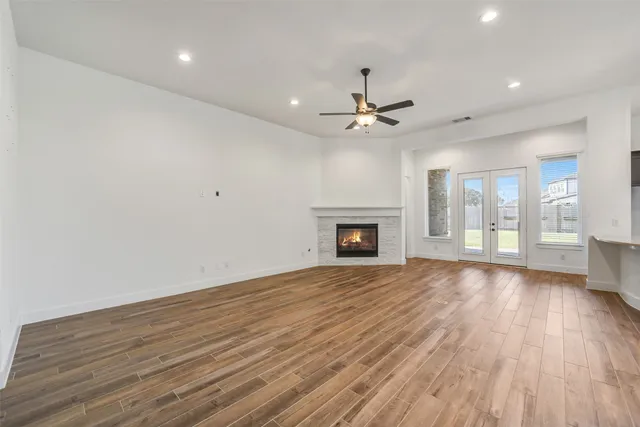 a view of an empty room with glass door and wooden floor