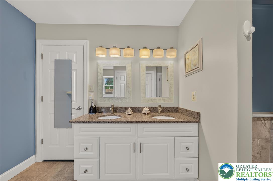 1702 Red Bud Road Quakertown, PA 18951 - Photo 39 of 68 Double vanity featuring granite counters and two mirrors, elegantly illuminated by a multi-bulb light fixture.