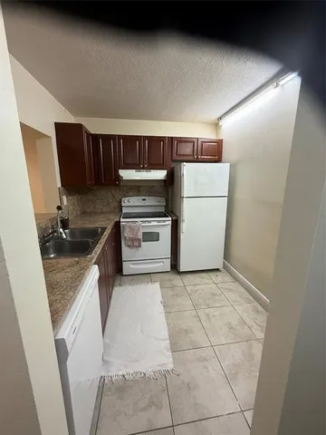 a kitchen with a refrigerator and a stove