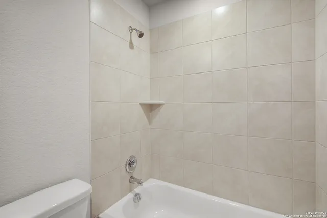 a bathroom with a granite countertop sink and a toilet