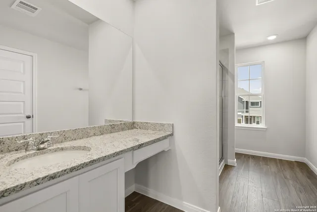 a view of a backyard with grass & fence