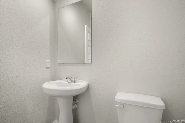 a bathroom with a sink a toilet and mirror