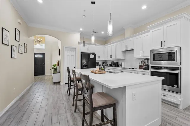 a kitchen that has a lot of cabinets a sink and a refrigerator