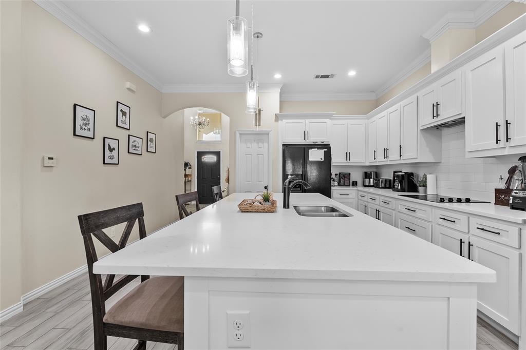 8002 County Road 1058 Rice, TX 75155 - Photo 4 of 19 a kitchen with kitchen island a dining table chairs and white cabinets