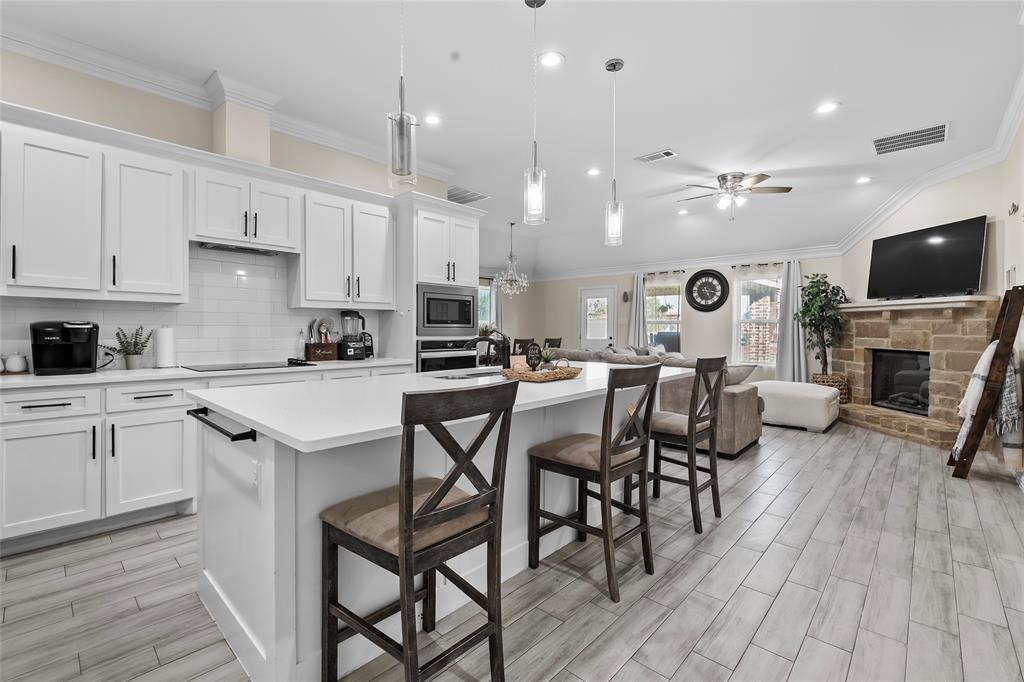 8002 County Road 1058 Rice, TX 75155 - Photo 19 of 19 a kitchen with a dining table chairs and white cabinets