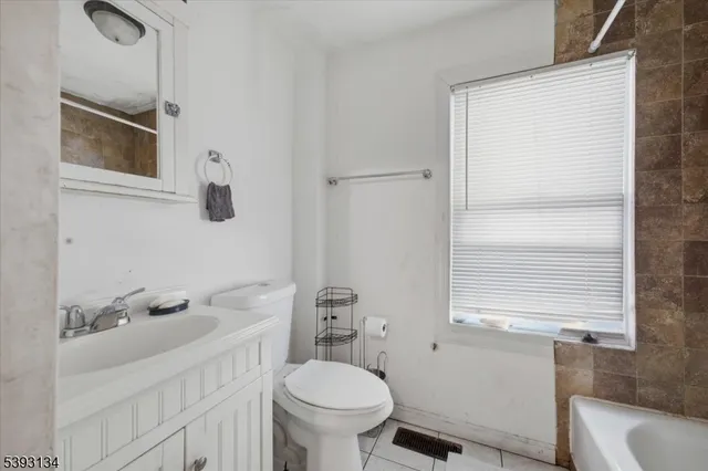 a bathroom with a sink a toilet and a window