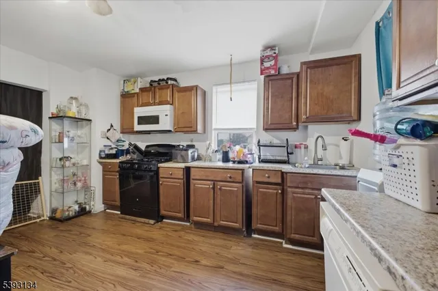 a kitchen with a sink stove top oven and refrigerator