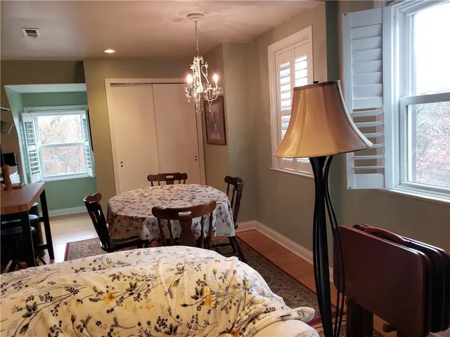 a bed room with a bed window and table chair
