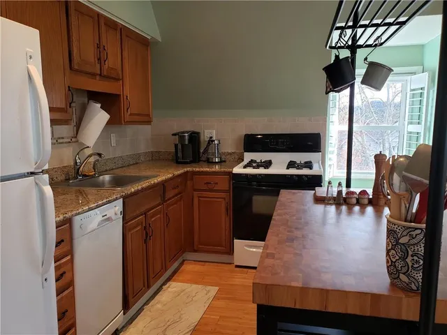 a kitchen with stainless steel appliances granite countertop a stove a sink and a refrigerator