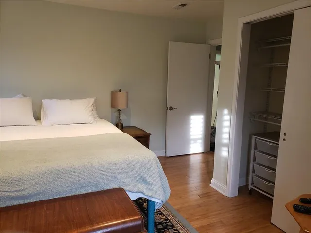 a bedroom with a bed and wooden floor