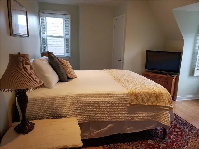 a bedroom with a bed and a flat tv screen