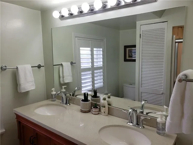 a bathroom with double vanity sinks and a mirror