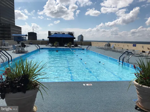 a view of a swimming pool with a patio and a yard