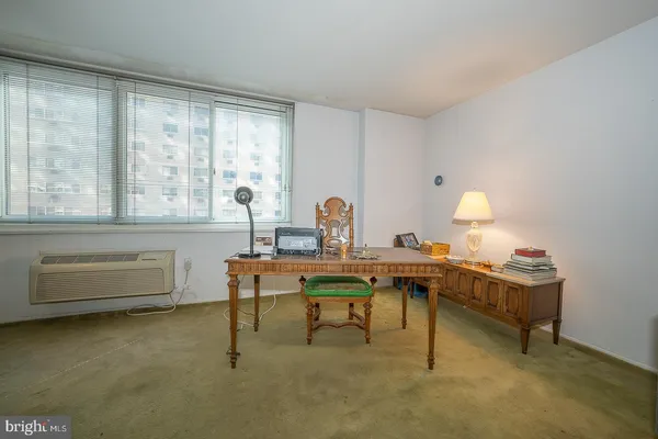 a view of a workspace with furniture and a window