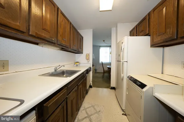 a kitchen with a sink a refrigerator and cabinets
