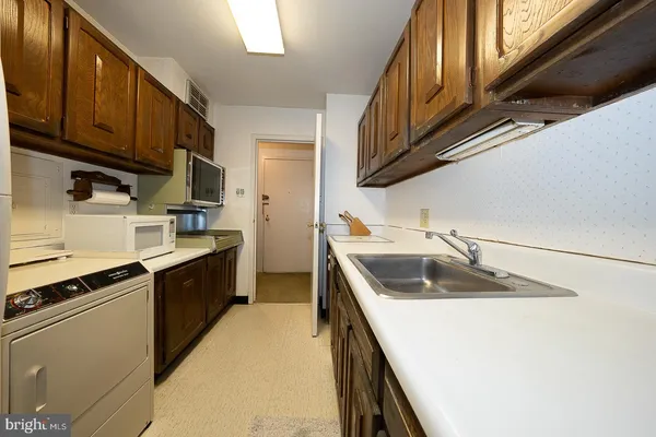 a kitchen with a sink stove top oven and cabinets