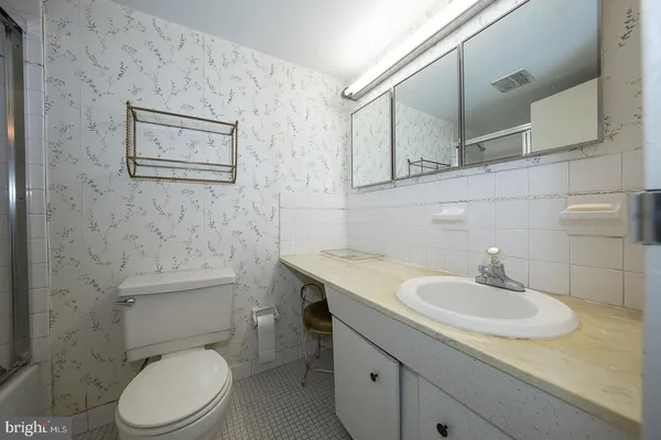 a bathroom with a granite countertop toilet sink and mirror