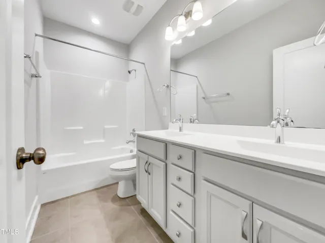 a bathroom with a double vanity sink toilet mirror and shower